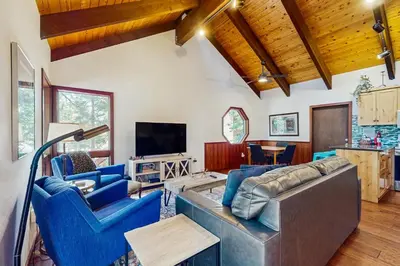 a living room with blue chairs and a couch at Tahoe Donner Tree House Retreat in Truckee