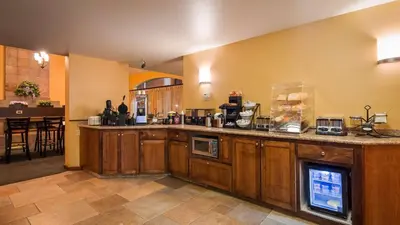 a large kitchen with a counter and a counter top at Best Western Palm Court Inn in Modesto