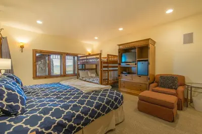a bedroom with a bed and a chair and a television at Skislope-Tahoe Villa in Truckee