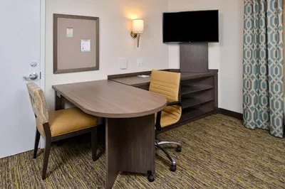 a hotel room with a desk and a television at Candlewood Suites - Lodi by IHG in Lodi