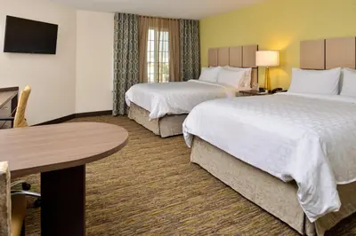 a hotel room with two beds and a table at Candlewood Suites - Lodi by IHG in Lodi