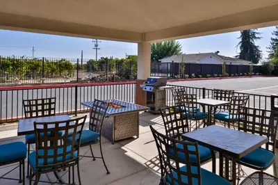 a patio with tables and chairs and a grill at Candlewood Suites - Lodi by IHG in Lodi