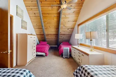 two beds in a room with wooden walls at Relaxed and Comfortable Family Gathering Home in Truckee