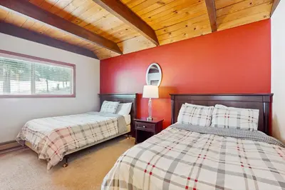 two beds in a room with red walls at Relaxed and Comfortable Family Gathering Home in Truckee