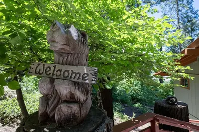 a statue of a bear holding a welcome sign at Yosemite Cub's Cabin in Yosemite West