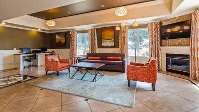 a living room with a couch and a table at Best Western Plus Rama Inn & Suites in Oakdale