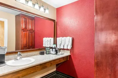 a bathroom with a sink and a red wall at Best Western Plus Yosemite Way Station in Mariposa
