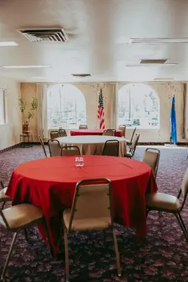 a conference room with tables and chairs and a flag at Carson City Plaza Hotel in Carson City