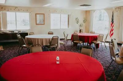 a room with two tables and chairs with red table cloth at Carson City Plaza Hotel in Carson City