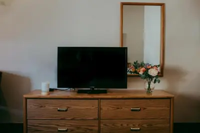 a television on top of a dresser with a mirror at Carson City Plaza Hotel in Carson City