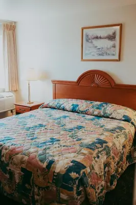 a bed in a hotel room with a quilt on it at Carson City Plaza Hotel in Carson City
