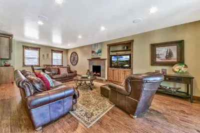 a living room with leather furniture and a fireplace at Lv12: luxury villa walk to the Beach in Glenbrook