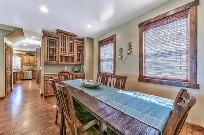 a kitchen and dining room with a wooden table and chairs at Lv12: luxury villa walk to the Beach in Glenbrook