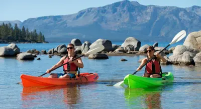two people in kayaks on a body of water at Lv12: luxury villa walk to the Beach in Glenbrook