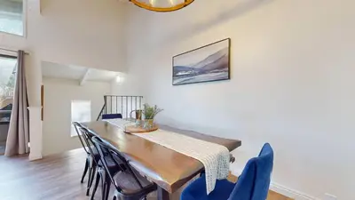 a dining room with a wooden table and blue chairs at Chateau De Montagne #6 Condo in Mammoth Lakes
