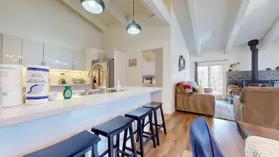 a kitchen with a bar with stools in a room at Chateau De Montagne #6 Condo in Mammoth Lakes