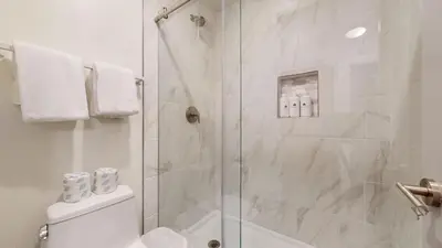 a white bathroom with a shower and a toilet at Chateau De Montagne #6 Condo in Mammoth Lakes