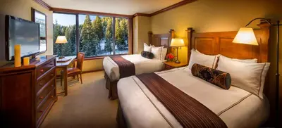 a hotel room with two beds and a desk and a television at Everline Resort and Spa, Lake Tahoe in Olympic Valley