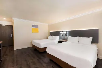 a hotel room with two beds and a desk at Comfort Inn Gilroy in Gilroy
