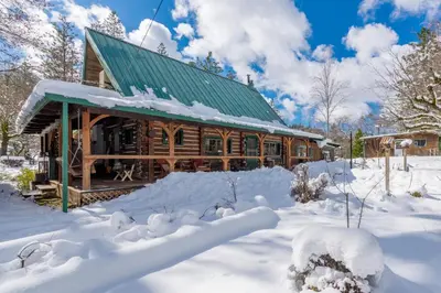 a log cabin in the snow with snow covered premises at The Davies Family Inn in Placerville