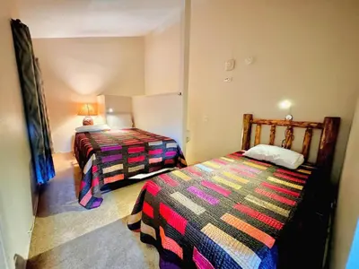 a small room with two beds and a lamp at Mammoth Lakes Crestview Condo #50 in Mammoth Lakes