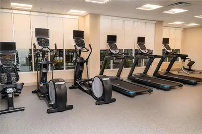 a gym with a row of treadmills and cell phones at Homewood Suites By Hilton Rancho Cordova, Ca in Rancho Cordova