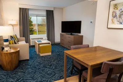 a hotel room with a living area with a television and a table at Homewood Suites By Hilton Rancho Cordova, Ca in Rancho Cordova