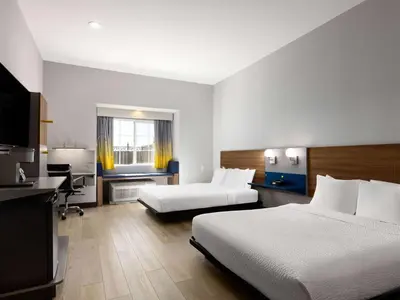 a hotel room with two beds and a desk at Microtel Inn & Suites by Wyndham Tracy in Tracy
