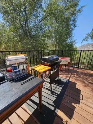 a grill sitting on a deck with a table at Sequoia Village in Three Rivers