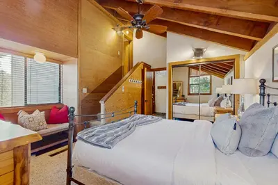 a bedroom with a bed with a ceiling fan at Northstar Condo with Forested Views in Truckee