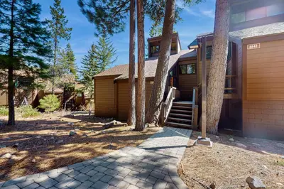 a house with trees in front of it at Northstar Condo with Forested Views in Truckee