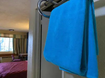 a blue towel hanging on a rack in a hotel room at Tiki Lodge Hotel Modesto in Modesto