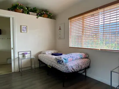 a room with a bed and a window and a table at WHOLE Family - Wolfgram in Sacramento