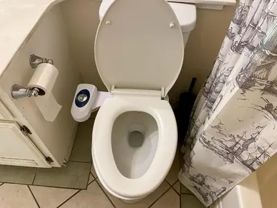 a white toilet in a bathroom with a roll of toilet paper at WHOLE Family - Wolfgram in Sacramento
