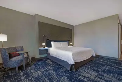 a hotel room with a bed and a chair at Hampton Inn Patterson, Ca in Patterson