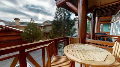 a wooden porch with a wooden table on a balcony at Juniper Crest #7 Condo in Mammoth Lakes