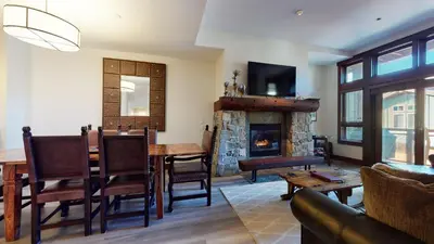 a living room with a table and a fireplace at Juniper Crest #7 Condo in Mammoth Lakes
