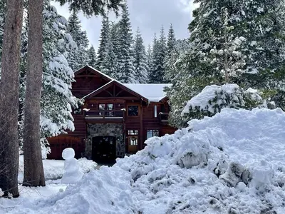 a log cabin with a pile of snow in front of it at Bear Meadows Lodge - Hot Tub - Tahoe Donner Home in Truckee