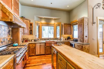 a kitchen with wooden cabinets and a stove top oven at Bear Meadows Lodge - Hot Tub - Tahoe Donner Home in Truckee