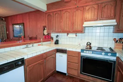 a kitchen with wooden cabinets and a stove top oven at Mammoth Ski Racquet Club 115 in Mammoth Lakes