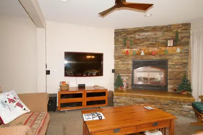 a living room with a fireplace and a tv at Mammoth Ski Racquet Club 82 in Mammoth Lakes