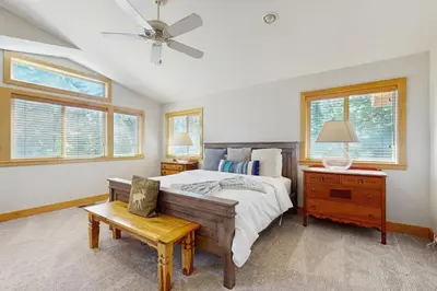 a bedroom with a bed and a table and windows at Agate Road Retreat in Carnelian Bay