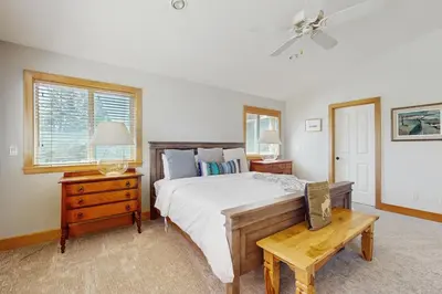 a bedroom with a bed and a table and windows at Agate Road Retreat in Carnelian Bay
