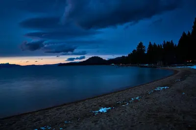 a beach with a cloudy sky and the water at The Landing Resort and Spa in South Lake Tahoe