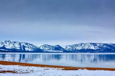 a view of a lake with snow covered mountains at The Landing Resort and Spa in South Lake Tahoe