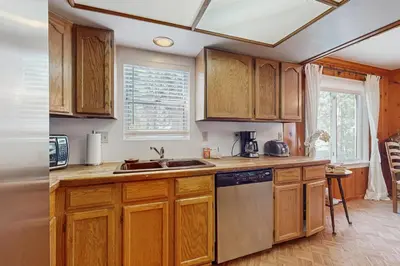 a kitchen with wooden cabinets and a sink at Casual and Cute Cabin Near the Lake in Tahoe Vista