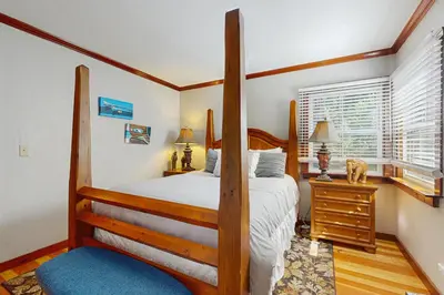 a bedroom with a four poster bed and a window at Casual and Cute Cabin Near the Lake in Tahoe Vista