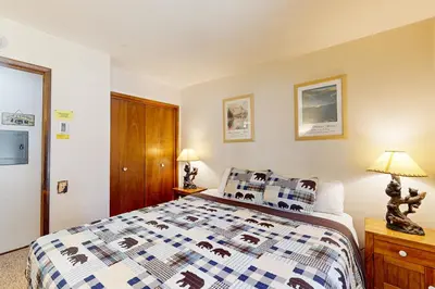 a bedroom with a bed with a blue and white quilt at Horizons 4 143 in Mammoth Lakes