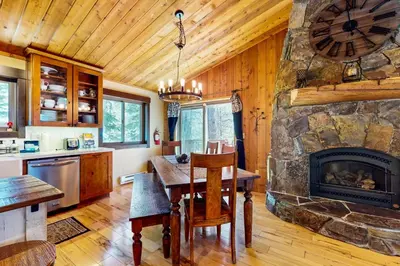 a kitchen and dining room with a stone fireplace at Tastefully-Updated, Classic Tahoe Family Home in Truckee