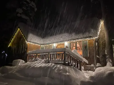 a house covered in snow at night with lights at Tahoma Meadows - Sugar Pine Cabin in Tahoma